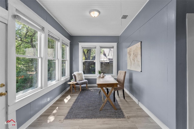 sunroom featuring visible vents, baseboards, and wood finished floors