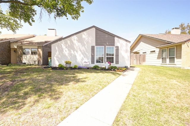 2109 Windy Dr, Garland, TX 75044 - view of front of house featuring a chimney, fence, a front lawn, and brick siding