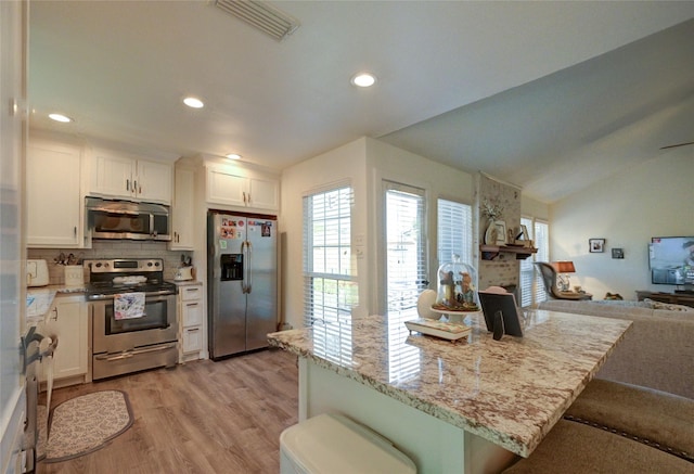 2109 Windy Dr, Garland, TX 75044 - kitchen featuring recessed lighting, open floor plan, white cabinetry, appliances with stainless steel finishes, and light wood finished floors