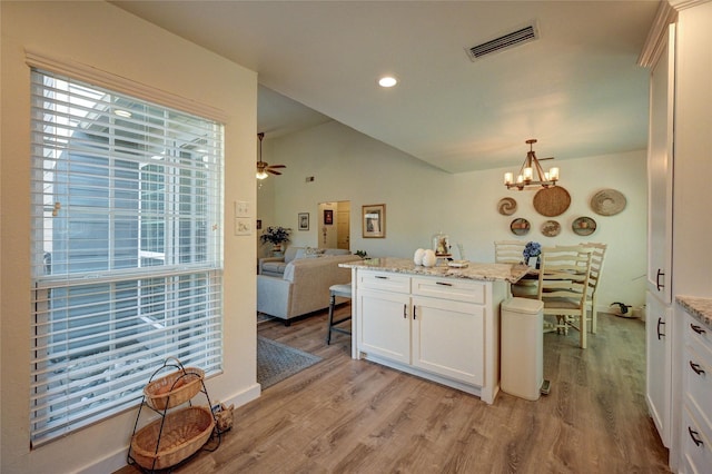 2109 Windy Dr, Garland, TX 75044 - kitchen with visible vents, white cabinets, open floor plan, light wood-type flooring, and vaulted ceiling