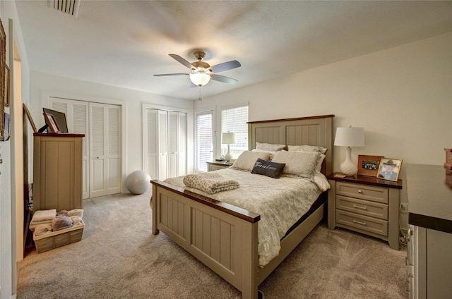 2109 Windy Dr, Garland, TX 75044 - bedroom with light carpet, ceiling fan, two closets, and visible vents