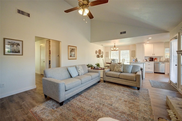 2109 Windy Dr, Garland, TX 75044 - living area featuring light wood-style flooring, visible vents, a wealth of natural light, and ceiling fan with notable chandelier