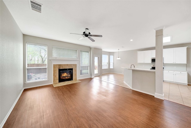 8625 Luzerne Dr, Mckinney, TX 75072 - unfurnished living room featuring baseboards, light wood-style flooring, a ceiling fan, visible vents, and a sink