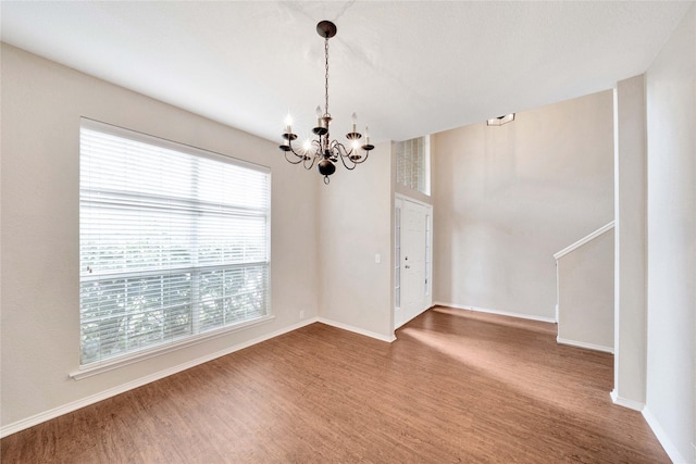 8625 Luzerne Dr, Mckinney, TX 75072 - spare room featuring wood finished floors, an inviting chandelier, and baseboards