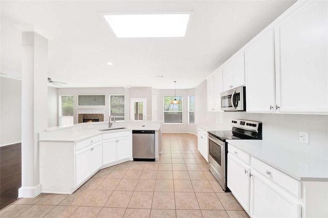 8625 Luzerne Dr, Mckinney, TX 75072 - kitchen featuring a peninsula, white cabinets, light countertops, a sink, and stainless steel appliances