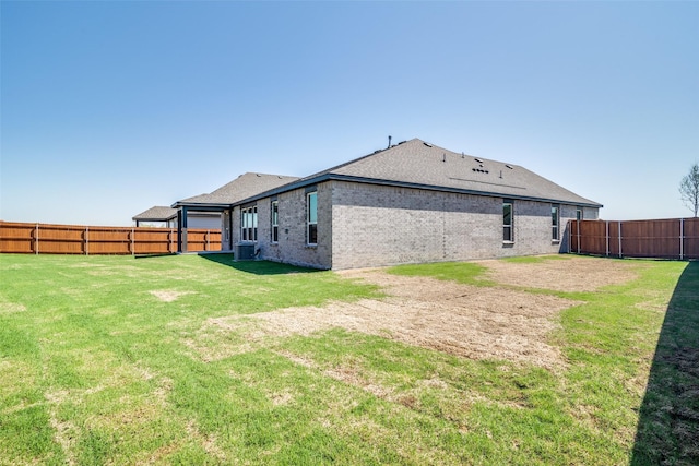 4031 Bedford Dr, Crandall, TX 75114 - back of house featuring central AC unit, a fenced backyard, a yard, brick siding, and roof with shingles