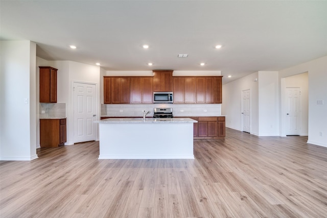 4031 Bedford Dr, Crandall, TX 75114 - kitchen with tasteful backsplash, light wood finished floors, an island with sink, and stainless steel appliances