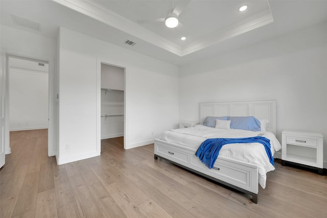 4729 Brockwell Dr, Carrollton, TX 75010 - bedroom with visible vents, baseboards, crown molding, a tray ceiling, and light wood-style flooring