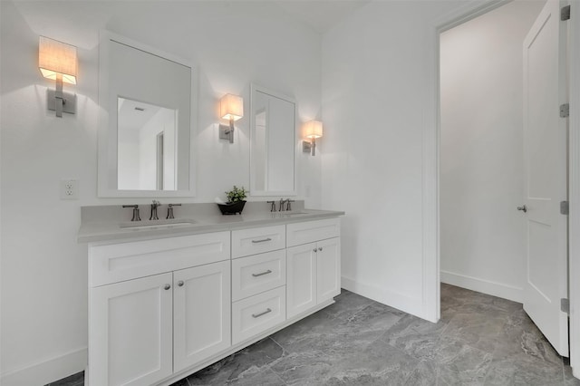 4729 Brockwell Dr, Carrollton, TX 75010 - bathroom featuring marble finish floor, double vanity, a sink, and baseboards