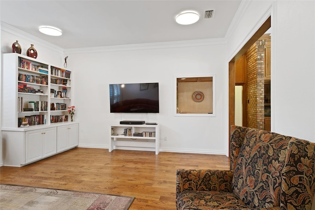 living area with ornamental molding, visible vents, baseboards, and light wood-type flooring