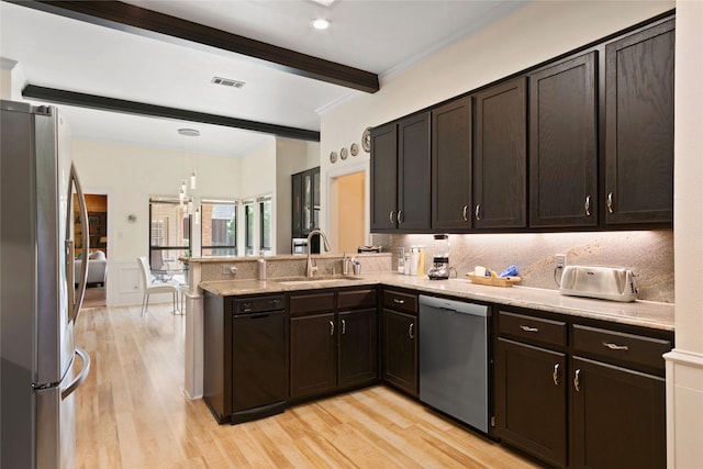kitchen with a peninsula, visible vents, a sink, stainless steel appliances, and beam ceiling
