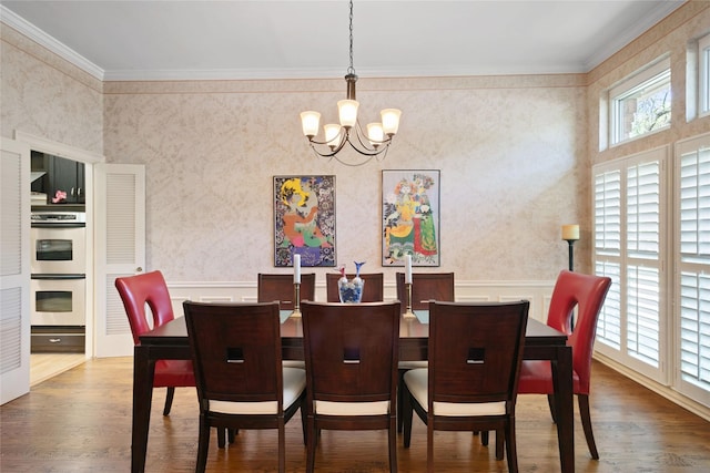 dining area with a notable chandelier, wood finished floors, and wainscoting