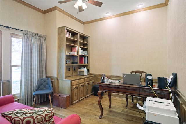 office area with light wood-type flooring, ceiling fan, crown molding, and a wainscoted wall