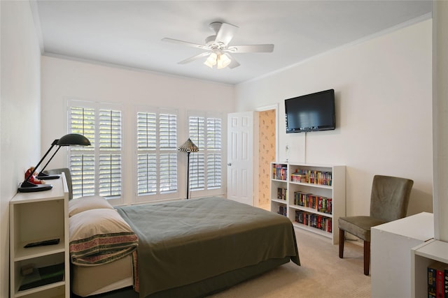carpeted bedroom featuring crown molding and ceiling fan