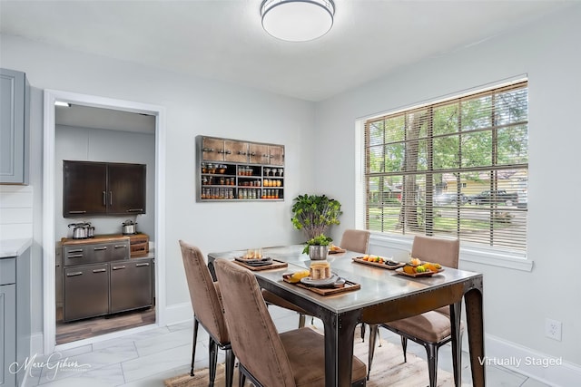 dining area featuring marble finish floor and baseboards
