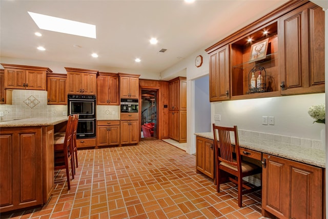 625 Estates Dr, Copper Canyon, TX 75077 - kitchen with a skylight, decorative backsplash, brick patterned floors, brown cabinetry, and recessed lighting