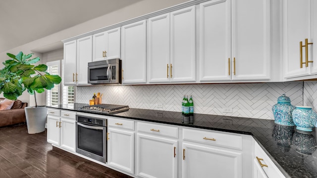 kitchen with tasteful backsplash, dark wood-type flooring, white cabinetry, and appliances with stainless steel finishes