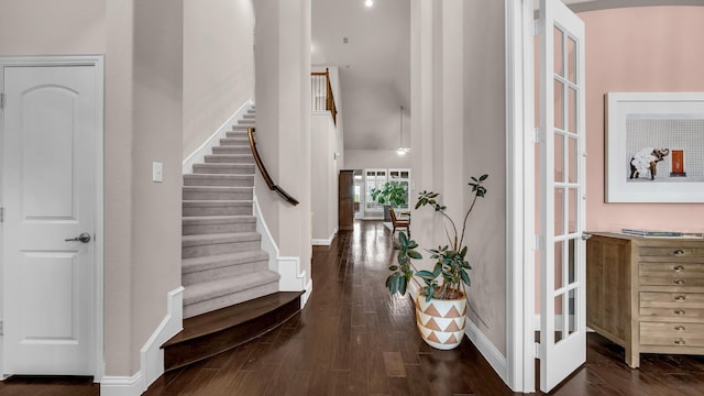 entrance foyer with baseboards, wood finished floors, and stairs