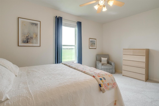 carpeted bedroom featuring baseboards and a ceiling fan