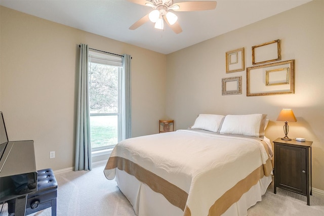 bedroom featuring baseboards, multiple windows, light carpet, and ceiling fan