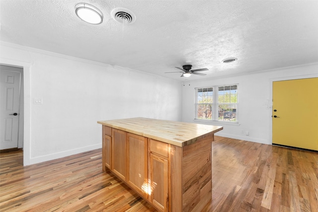 1909 Sycamore Dr, Mesquite, TX 75149 - kitchen with wooden counters, a textured ceiling, light wood finished floors, a ceiling fan, and ornamental molding