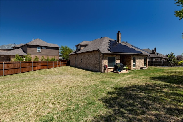 5100 Tortola Ln, Fort Worth, TX 76244 - rear view of house featuring roof mounted solar panels, a chimney, and brick siding