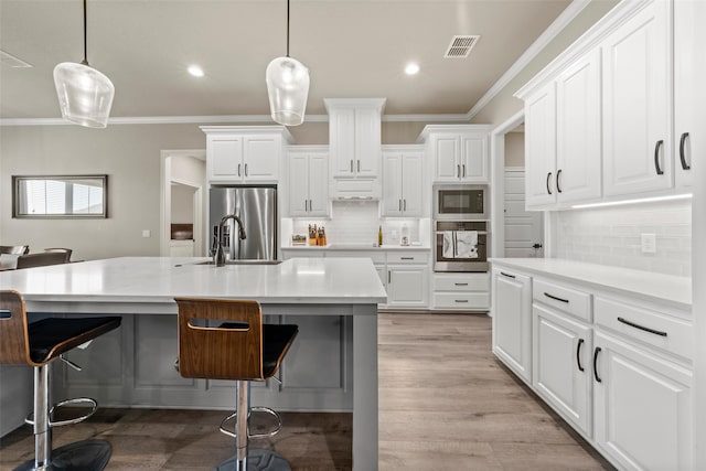 10108 Feather Trace Ln, Waco, TX 76712 - kitchen featuring appliances with stainless steel finishes, a sink, a breakfast bar, backsplash, and ornamental molding