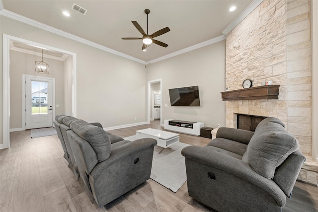 10108 Feather Trace Ln, Waco, TX 76712 - living room with light wood-style flooring, a ceiling fan, baseboards, crown molding, and a stone fireplace