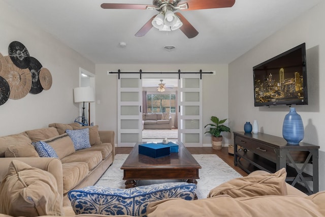 216 Belmont St, Hurst, TX 76053 - living area featuring a barn door, wood finished floors, a ceiling fan, and baseboards