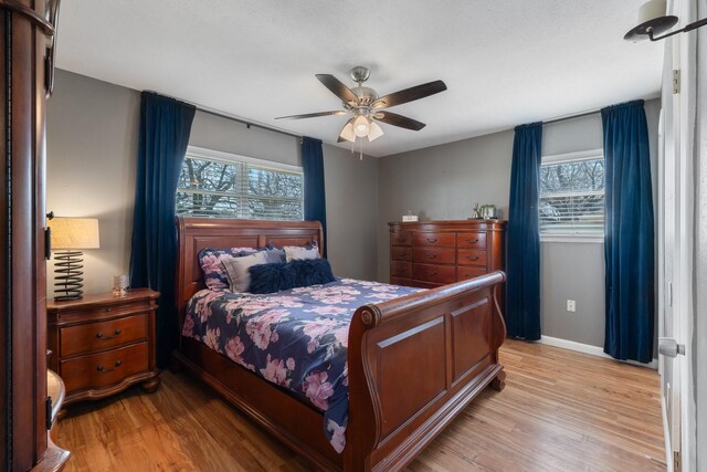 216 Belmont St, Hurst, TX 76053 - bedroom with light wood finished floors, baseboards, and ceiling fan