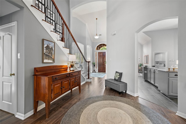 953 Waterbury Way, Keller, TX 76248 - foyer entrance with a high ceiling, dark wood-style flooring, stairway, arched walkways, and baseboards