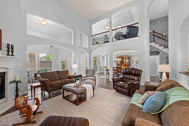 953 Waterbury Way, Keller, TX 76248 - living room with arched walkways, wood finished floors, a high ceiling, a ceiling fan, and a glass covered fireplace
