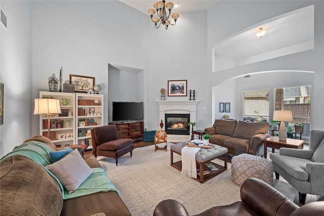 953 Waterbury Way, Keller, TX 76248 - living room with arched walkways, a towering ceiling, a chandelier, and a glass covered fireplace