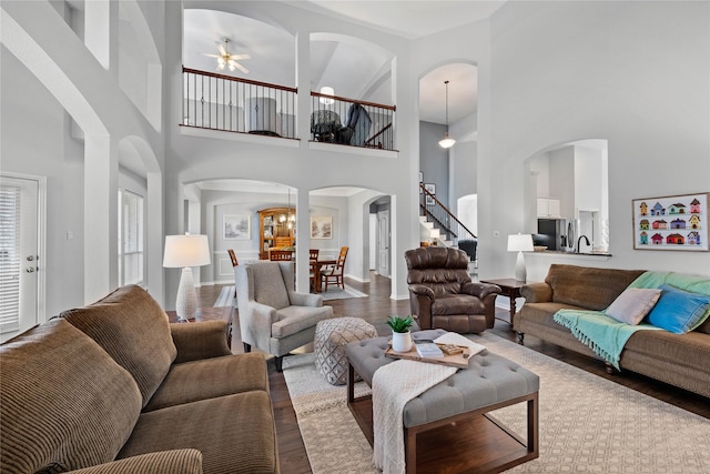 953 Waterbury Way, Keller, TX 76248 - living area with wood finished floors, arched walkways, a ceiling fan, a towering ceiling, and stairs