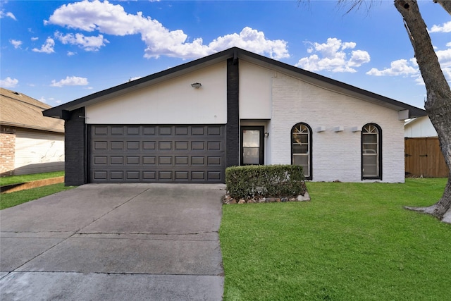 view of front of property with a garage, driveway, a front lawn, and brick siding