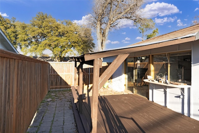 wooden terrace with a fenced backyard