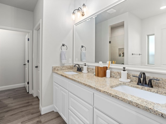 1317 Thistle Hill Trl, Weatherford, TX 76087 - bathroom featuring tiled shower, baseboards, a sink, and wood finished floors