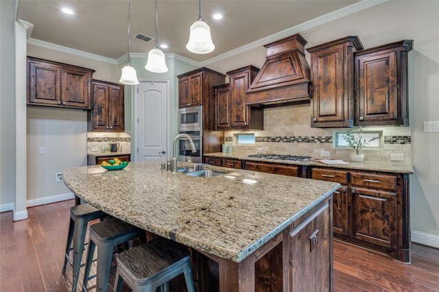 kitchen featuring visible vents, custom range hood, a sink, baseboards, and stainless steel appliances