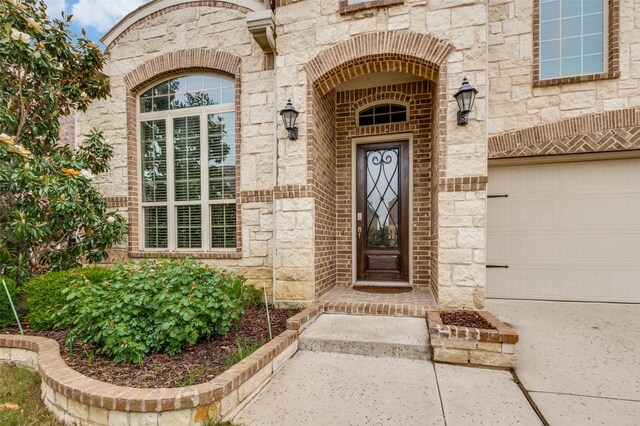 property entrance featuring stone siding and a garage