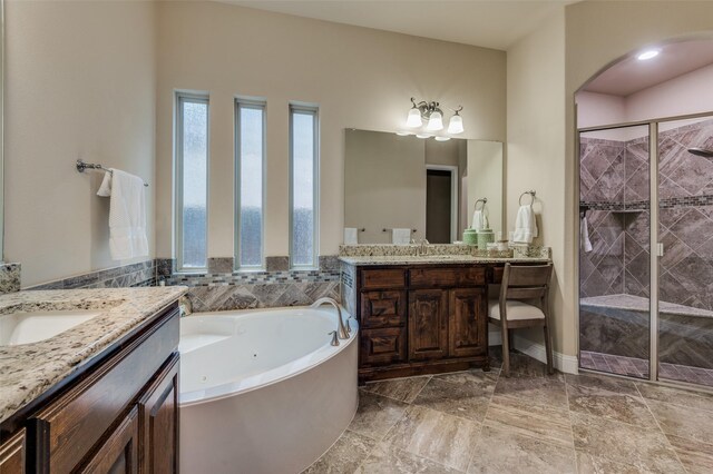 full bath with a sink, a shower stall, a garden tub, and two vanities