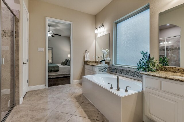 ensuite bathroom with ceiling fan, two vanities, a shower stall, ensuite bathroom, and a garden tub