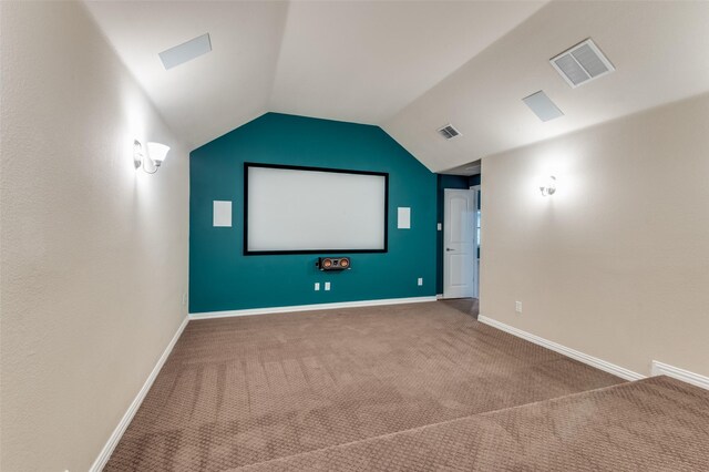 home theater with carpet floors, baseboards, visible vents, and vaulted ceiling