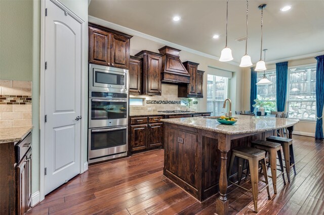 kitchen with backsplash, appliances with stainless steel finishes, ornamental molding, and premium range hood