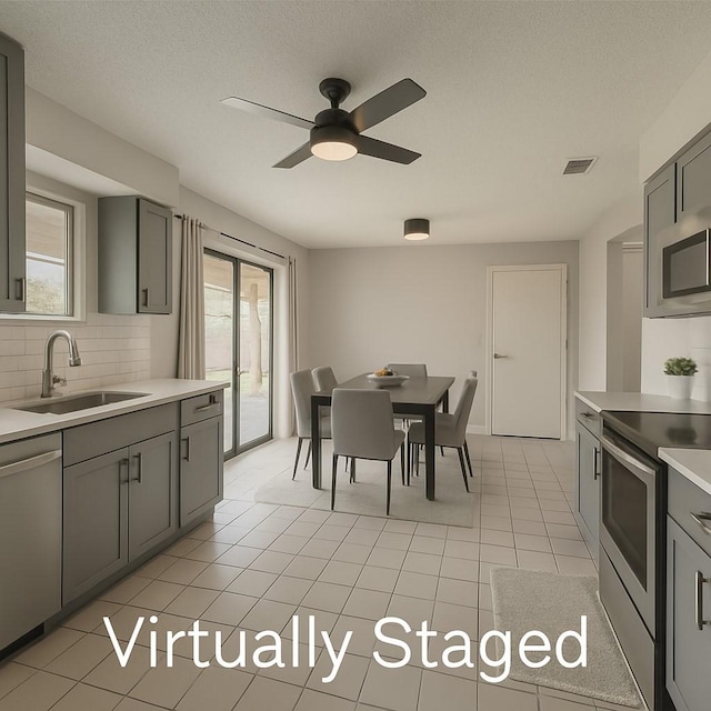 2205 Meadow Ln, Garland, TX 75040 - kitchen featuring a sink, gray cabinetry, and stainless steel appliances