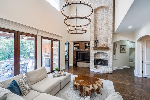 2890 Creekwood Ln, Prosper, TX 75078 - living area featuring arched walkways, a chandelier, wood finished floors, a high ceiling, and a fireplace