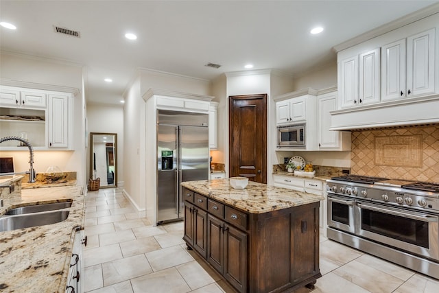 2890 Creekwood Ln, Prosper, TX 75078 - kitchen with built in appliances, under cabinet range hood, white cabinetry, dark brown cabinets, and tasteful backsplash
