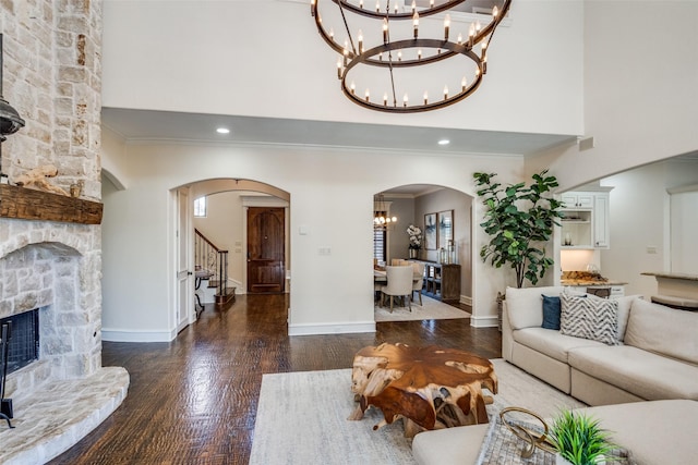 2890 Creekwood Ln, Prosper, TX 75078 - living area featuring a chandelier, arched walkways, a towering ceiling, ornamental molding, and wood finished floors