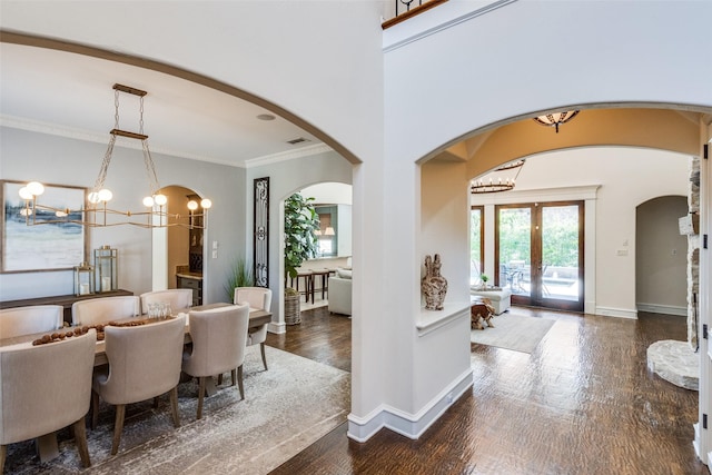2890 Creekwood Ln, Prosper, TX 75078 - dining area featuring a chandelier, dark wood-style floors, arched walkways, crown molding, and french doors