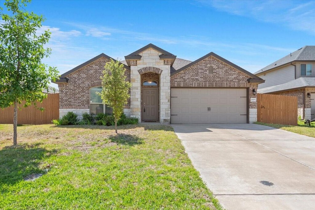 6405 Elephant Butte Dr, Waco, TX 76708 - french country style house with a garage, brick siding, and fence