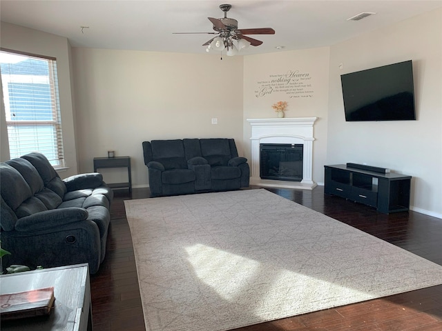 9140 Blackstone Dr, Providence Village, TX 76227 - living room with a glass covered fireplace, baseboards, dark wood finished floors, visible vents, and ceiling fan
